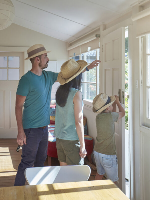 Family wearing straw hats standing in house